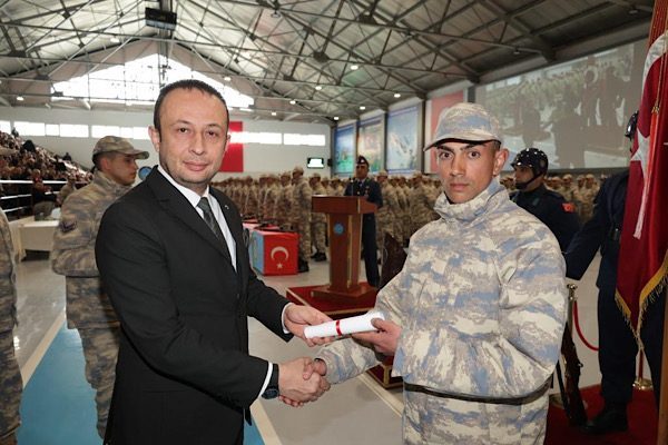 Eğitimlerini başarıyla tamamlayan erler, Türk Bayrağı ve silah üzerine el
